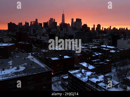 New York, États-Unis.29th janvier 2022.Le ciel change de tons de rouge et d'orange au coucher du soleil derrière les gratte-ciel de Manhattan tandis que les toits et les rues du Lower East Side restent couverts de neige après une fête de Pâques avec des conditions de blizzard qui a frappé la côte est de New York le samedi 29 janvier 2022.Des parties de la côte du centre de l'Atlantique ont été recouvertes de neige dans l'est de la Nouvelle-Angleterre.Photo de John Angelillo/UPI crédit: UPI/Alay Live News Banque D'Images