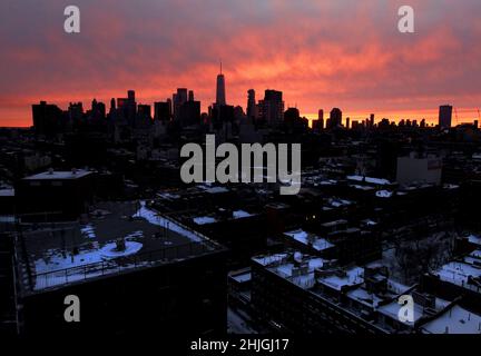 New York, États-Unis.29th janvier 2022.Le ciel change de tons de rouge et d'orange au coucher du soleil derrière les gratte-ciel de Manhattan tandis que les toits et les rues du Lower East Side restent couverts de neige après une fête de Pâques avec des conditions de blizzard qui a frappé la côte est de New York le samedi 29 janvier 2022.Des parties de la côte du centre de l'Atlantique ont été recouvertes de neige dans l'est de la Nouvelle-Angleterre.Photo de John Angelillo/UPI crédit: UPI/Alay Live News Banque D'Images