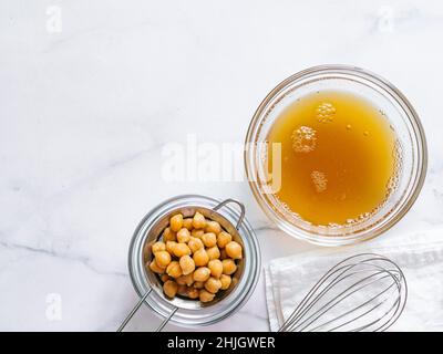 Aquafaba dans un bol.Eau de pois chiches saumure aquafaba .Remplacement de l'œuf en cococokéfaction.Concept vegan.Vue de dessus ou plan de travail.Copier l'espace Banque D'Images