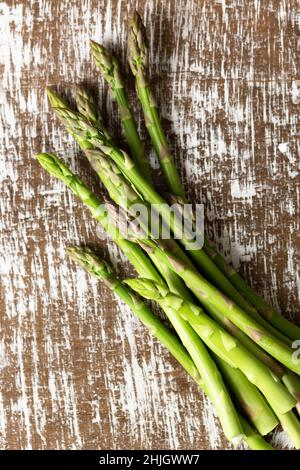 Bouquet d'asperges vertes sur fond de bois. Banque D'Images