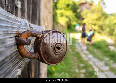 Ancienne serrure de grange rouillée.Serrure fermée sur la poignée métallique d'une porte en bois.Serrure en gros plan à la porte dans le village bulgare. Banque D'Images