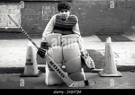 Un adolescent jouant du gardien de but sur son équipe de hockey de rue.Il porte des équipements à petit budget faits maison. Banque D'Images