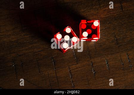 Dés professionnels de style casino sur une table en bois sous un éclairage de haute-clé. Banque D'Images