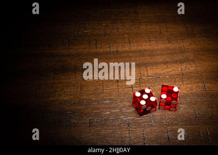 Dés professionnels de style casino sur une table en bois sous un éclairage de haute-clé. Banque D'Images