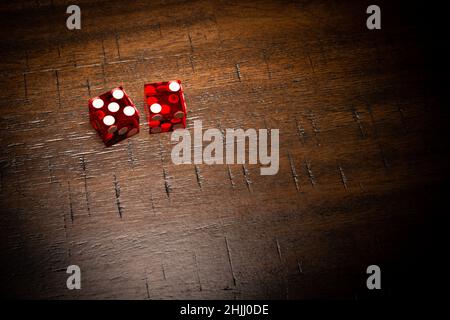 Dés professionnels de style casino sur une table en bois sous un éclairage de haute-clé. Banque D'Images