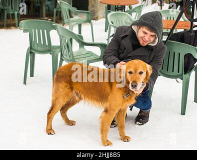 Un blogueur de sexe masculin filait avec son chien pour un blog en plein air en hiver.Concept de blogging de voyage et propriétaire d'animal de compagnie Banque D'Images