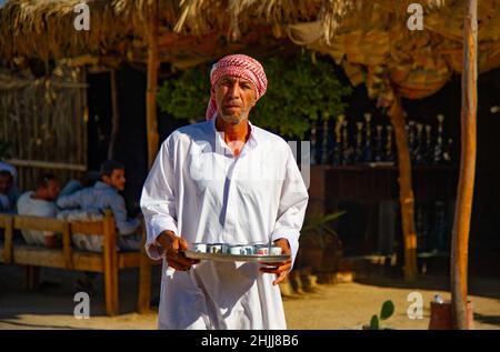 Bédouin égyptien servant du thé aux touristes visitant le village Banque D'Images