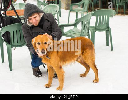 Un blogueur de sexe masculin filait avec son chien pour un blog en plein air en hiver.Concept de blogging de voyage et propriétaire d'animal de compagnie Banque D'Images