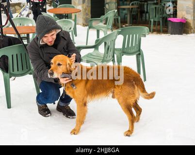 Un blogueur de sexe masculin filait avec son chien pour un blog en plein air en hiver.Concept de blogging de voyage et propriétaire d'animal de compagnie Banque D'Images