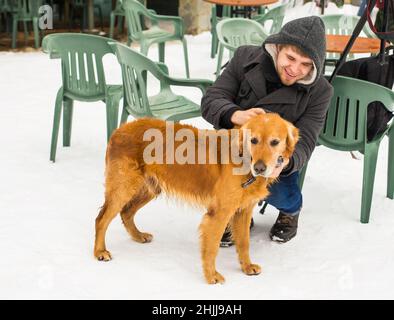 Un blogueur de sexe masculin filait avec son chien pour un blog en plein air en hiver.Concept de blogging de voyage et propriétaire d'animal de compagnie Banque D'Images