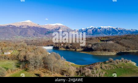 Vue aérienne du lac de Scandarello à Amatrice, Italie.Paysage d'automne avec lac, forêt et montagnes avec des sommets enneigés en arrière-plan. Banque D'Images