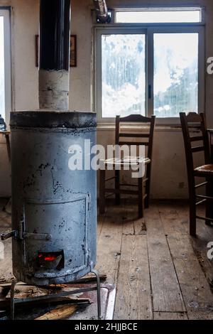 Ancien poêle en métal dans une ancienne maison traditionnelle avec parquet, dans la région montagneuse d'Agrafa, près de la ville de Karpenisi, Grèce, Europe. Banque D'Images