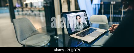 Femme d'affaires méconnue assistant à une réunion virtuelle dans un bureau.Femme d'affaires anonyme utilisant un ordinateur portable pour passer des appels vidéo à ses partenaires commerciaux.FEM Banque D'Images