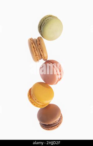 Macarons colorés tombant sur un fond clair Banque D'Images