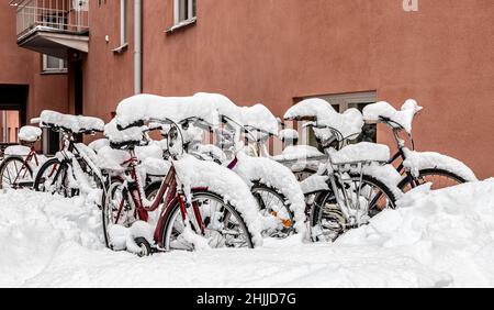 Vélos enneigés garés dans la cour d'un immeuble résidentiel de Vilhonvuori, Helsinki, Finlande. Banque D'Images