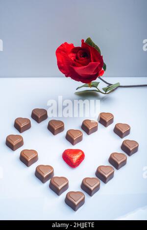 Helsinki / Finlande - 29 JANVIER 2022 : gros plan des confiseries au chocolat en forme de coeur, et des roses rouges sur fond blanc vif. Banque D'Images