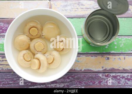 Champignons en conserve soufflez sur fond blanc Banque D'Images