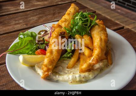 Poisson et frites pané à la bière australienne avec salade et sauce tartare appropriée Banque D'Images