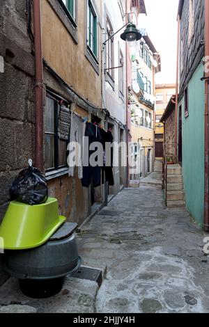 Petite rue pavée du centre-ville.Authentique vieille ville de Porto, Portugal.Séchage de linge lavé accroché à une corde sur la façade du bâtiment Banque D'Images