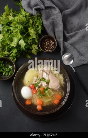 Soupe de nouilles de poulet au Caldo de Gallina avec œufs durs et herbes.La soupe péruvienne classique de nouilles de poulet. Banque D'Images