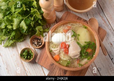 Soupe de nouilles de poulet au Caldo de Gallina avec œufs durs et herbes.La soupe péruvienne classique de nouilles de poulet. Banque D'Images