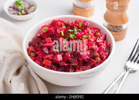 Vinaigrette russe traditionnelle avec betteraves, pommes de terre, carottes et choucroute sur un fond gris.Vue latérale, gros plan. Banque D'Images