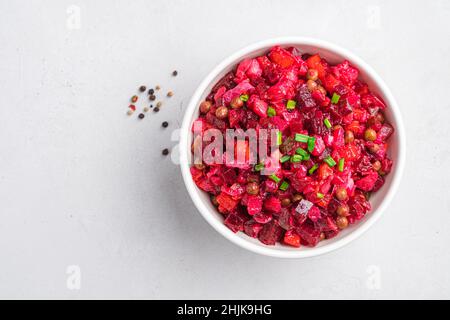 Vinaigrette de salade de betteraves aux herbes fraîches sur fond gris dans un bol blanc.Salade végétarienne.Vue de dessus, espace de copie. Banque D'Images
