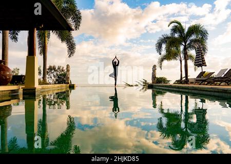 Un homme debout au bord de la piscine à débordement Banque D'Images