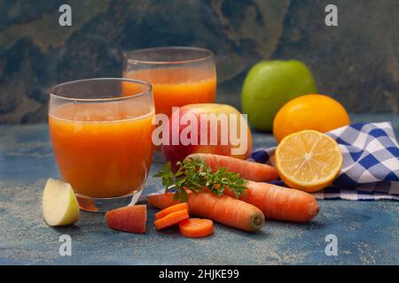 Jus frais bio naturel fait de carottes et de pommes sur fond blanc.Smoothie sain aux carottes, aux pommes et au citron. Banque D'Images