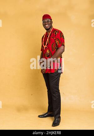 Igbo traditionnellement habillé homme d'affaires debout rire Banque D'Images