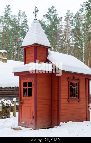 Ancienne chapelle en bois rouge letton avec crucifix Banque D'Images