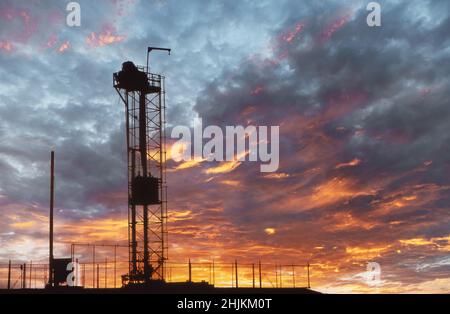 Silhouette de l'engin de forage pétrolier et gazier au coucher du soleil Banque D'Images