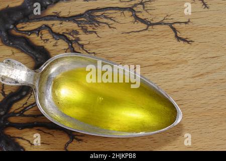 Cuillère avec huile de poisson dans une cuillère en métal sur fond en bois.Vitamines Omega 3 en cuillère gros plan Banque D'Images