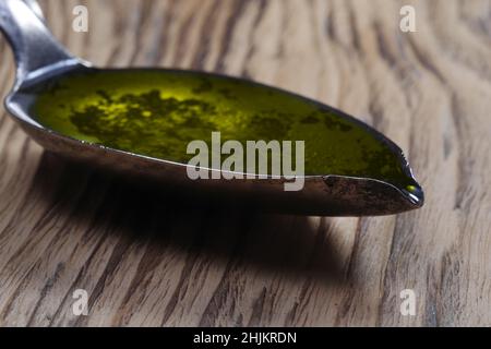 Poisson gras de morue huile de foie oméga gel capsules dans une cuillère en métal sur fond de bois Banque D'Images