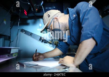 MER DES PHILIPPINES (janv23, 2022) Spécialiste des opérations 2nd classe Owen Pattersontaylor, de San Diego, trace la position des contacts de surface sur un panneau de manœuvre dans la salle des opérations tactiques à bord du porte-avions USS Abraham Lincoln (CVN 72) de la classe Nimitz.Faisant partie de la flotte du Pacifique des États-Unis, les unités affectées aux groupes de grève des transporteurs Carl Vinson et Abraham Lincoln, aux groupes prêts à l'amphibie d'Amérique et d'Essex, aux côtés de la Force d'autodéfense maritime du Japon, mènent une formation pour préserver et protéger une région Indo-Pacifique libre et ouverte. Banque D'Images