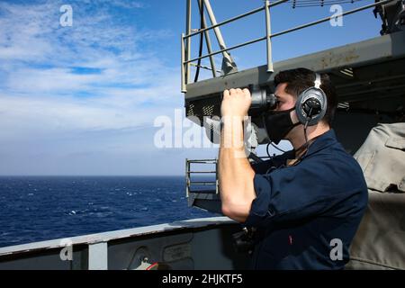 MER DES PHILIPPINES (janv23, 2022) le Matelot de 1re classe de Boatswain, l’apprenti Yerson Zamora, de Houston, Texas, utilise des jumelles pour suivre les contacts de surface comme point d’observation arrière tribord à bord du porte-avions de la classe Nimitz USS Abraham Lincoln (CVN 72).Faisant partie de la flotte du Pacifique des États-Unis, les unités affectées aux groupes de grève des transporteurs Carl Vinson et Abraham Lincoln, aux groupes prêts à l'amphibie d'Amérique et d'Essex, aux côtés de la Force d'autodéfense maritime du Japon, mènent une formation pour préserver et protéger une région Indo-Pacifique libre et ouverte. Banque D'Images