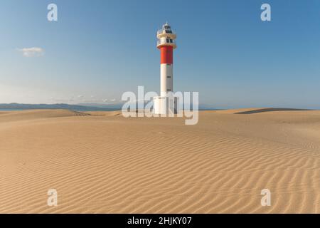 Phare de Delta del Ebro parmi les dunes de la plage de Fangar au coucher du soleil par jour ensoleillé Banque D'Images