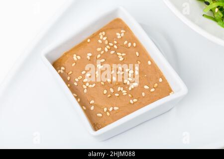 Sauce brune aux arachides pour la salade de chuka.Sur fond blanc. Banque D'Images