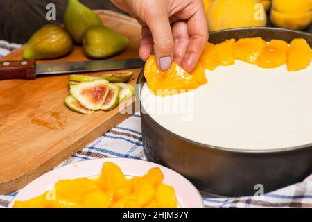 Cuisson du cheesecake.Le cuisinier décorera le cheesecake avec des tranches de fruits. Banque D'Images