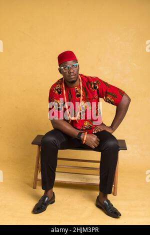 Igbo, homme d'affaires habillé de façon traditionnelle, assis Banque D'Images