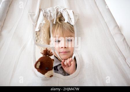 Enfant blond en forme de jeune enfant, portant une tipi avec un singe farci à la maison Banque D'Images