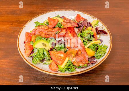 Salade de laitue, bacon frit, avocat et graines de citrouille, tomate, huile et vinaigre Banque D'Images