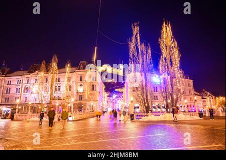 LJUBLJANA, SLOVÉNIE - 15 JANVIER 2022 : vue sur les personnes marchant sur la place Preseren et le pont Tromostovje Triple avec le château de Ljubljana Banque D'Images