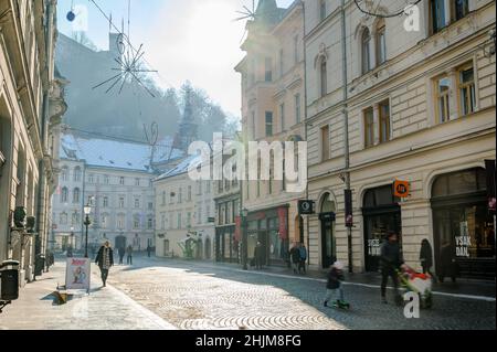 LJUBLJANA, SLOVÉNIE - 15 JANVIER 2022 : vue sur les personnes marchant dans la rue Stritarjeva avec le château de Ljubljana en arrière-plan Banque D'Images