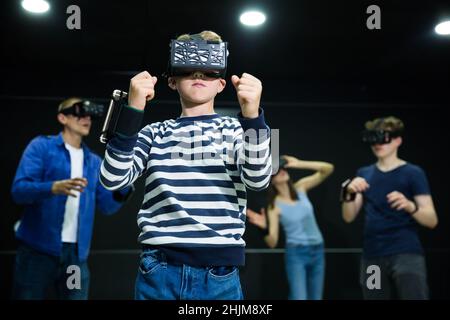 Emotive Tween boy jouant à vr jeu avec la famille Banque D'Images