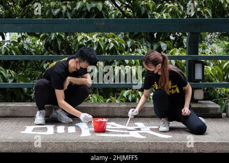 Les étudiants de l'Union étudiante de l'Université de Hong Kong repeignent le slogan le 11 juin 2021 dans le cadre de la tradition de mémoriser et de pleurer les victimes en juin 4, 1989 massacre à Beijing.l'Université de Hong Kong le samedi,Le 29 janvier a couvert un slogan sur un pont dans son campus, qui commémore le massacre de juin 4.Une autre mesure après que l'école ait supprimé le pilier de la honte érigé sur le campus de l'école.Les fonctionnaires de l'école ont affirmé que le travail faisait partie de son calendrier d'entretien régulier. Banque D'Images