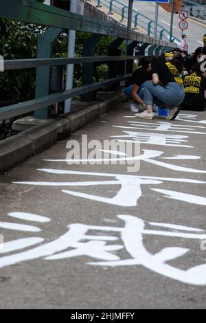 Les étudiants de l'Union étudiante de l'Université de Hong Kong repeignent le slogan le 11 juin 2021 dans le cadre de la tradition de mémoriser et de pleurer les victimes en juin 4, 1989 massacre à Beijing.l'Université de Hong Kong le samedi,Le 29 janvier a couvert un slogan sur un pont dans son campus, qui commémore le massacre de juin 4.Une autre mesure après que l'école ait supprimé le pilier de la honte érigé sur le campus de l'école.Les fonctionnaires de l'école ont affirmé que le travail faisait partie de son calendrier d'entretien régulier. Banque D'Images