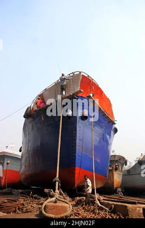 JANVIER 30,01,2022,DHAKA,BANGLADESH- des travailleurs de chantier naval vus autour des navires le long de la rive du fleuve Buriganga.L'industrie de la construction navale à Bangl Banque D'Images