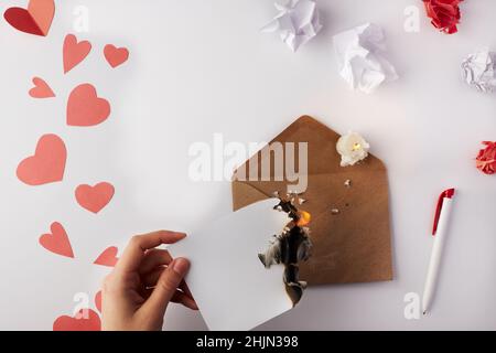 Saint Valentin.Le coeur d'une Valentin brûle sur une enveloppe dans la main d'une fille.Vue de dessus.Copier l'espace.Placer pour le texte. Banque D'Images