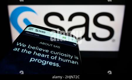 Téléphone mobile avec page Web de la société américaine de logiciels d'analyse SAS Institute Inc. À l'écran devant le logo.Faites la mise au point dans le coin supérieur gauche de l'écran du téléphone. Banque D'Images
